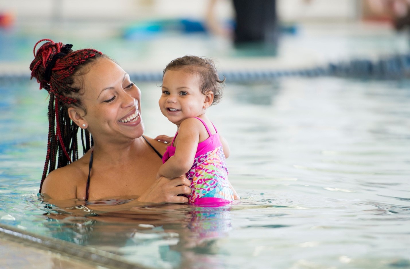 Woman holds child in pool